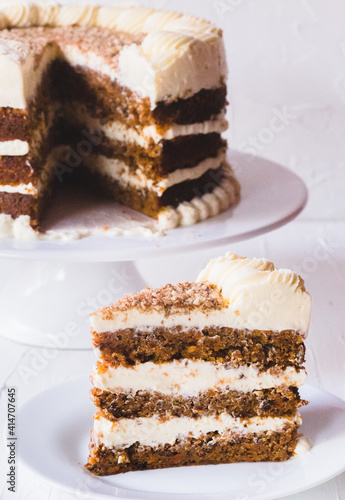 Carrot cake with cream cheese frosting on a white background