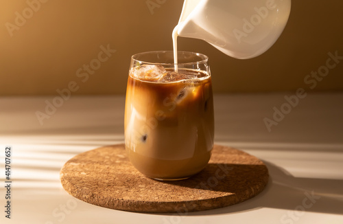 фотографія Milk cream is poured into a iced cold brew coffee