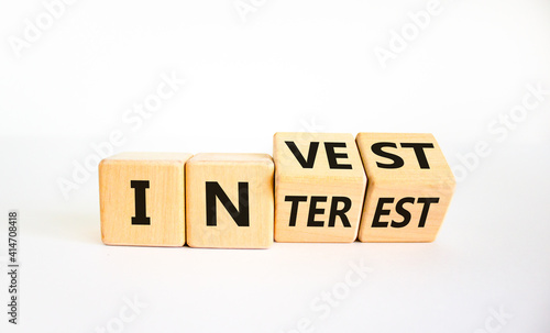 Invest or interest symbol. Turned wooden cubes and changed the word 'invest' to 'interest'. Beautiful white background, copy space. Business and invest or interest concept.