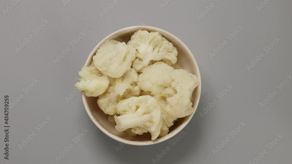 Boiled hot cauliflower in bowl on gray background. Top view, flat lay Boiled hot cauliflower in bowl on gray background. Top view, flat lay
