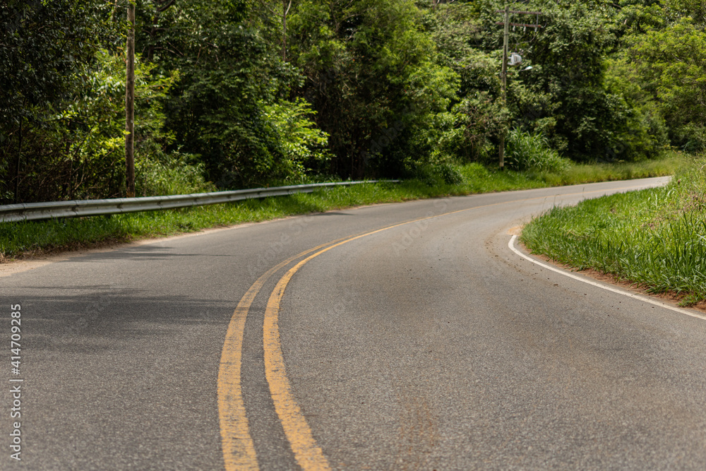 Curved road, bush around and empty Curved road, bush around and empty