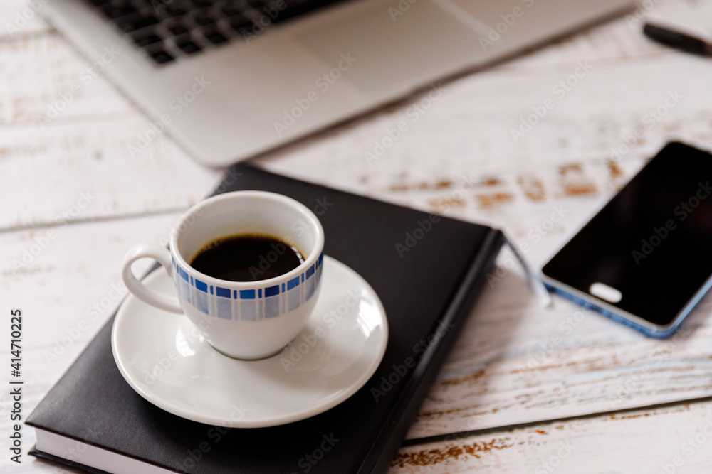 Flat lay on washed wooden background with cup of cofee, laptop and a cel phone Flat lay on washed wooden background with cup of cofee, laptop and a cel phone