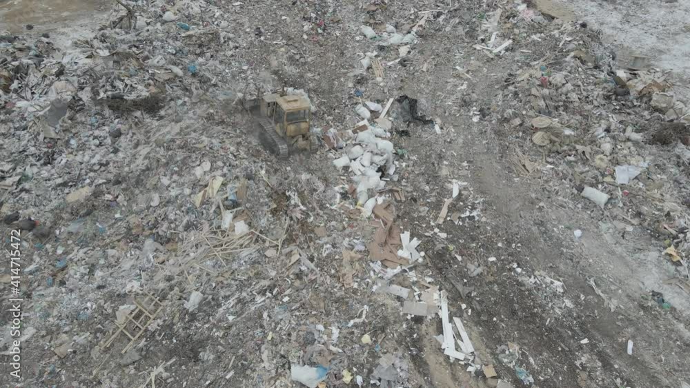 bulldozer tractor pushes garbage from a mountain in a city dump bulldozer tractor pushes garbage from a mountain in a city dump
