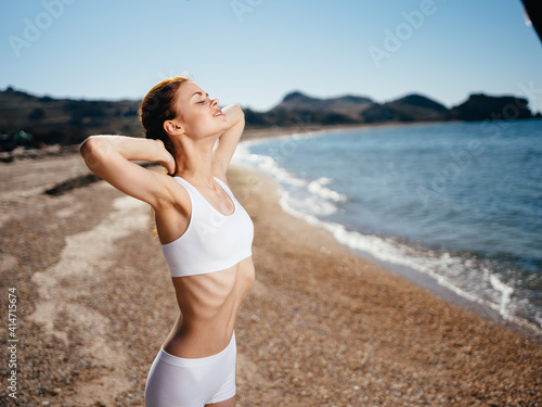 Cheerful woman in swimsuit in the morning on the island Exotic travel fresh air