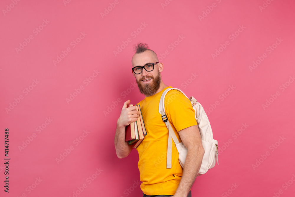 Adult student cheerful casual wear guy with beard and backpack holding books isolated on pink background Adult student cheerful casual wear guy with beard and backpack holding books isolated on pink background