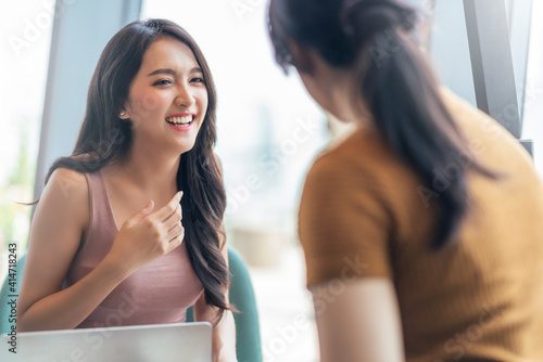 attractive asian positive female happiness conversation smiling laugh cheeful talking with friend at cafe restaurant with natural light from window casual lifestyle concept