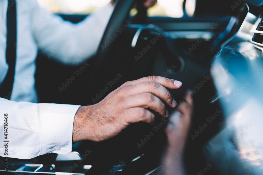 Anonymous man adjusting settings in car Anonymous man adjusting settings in car