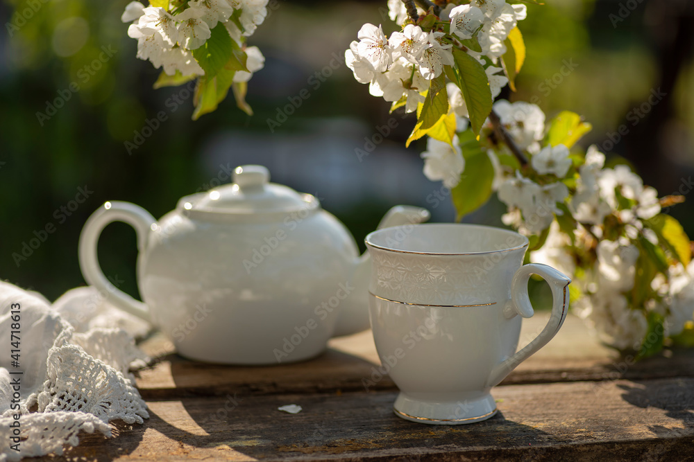 Tea set, cherry blossom branches, wooden table. Outdoor breakfast, picnic, brunch, spring mood. Soft focus Tea set, cherry blossom branches, wooden table. Outdoor breakfast, picnic, brunch, spring mood. Soft focus