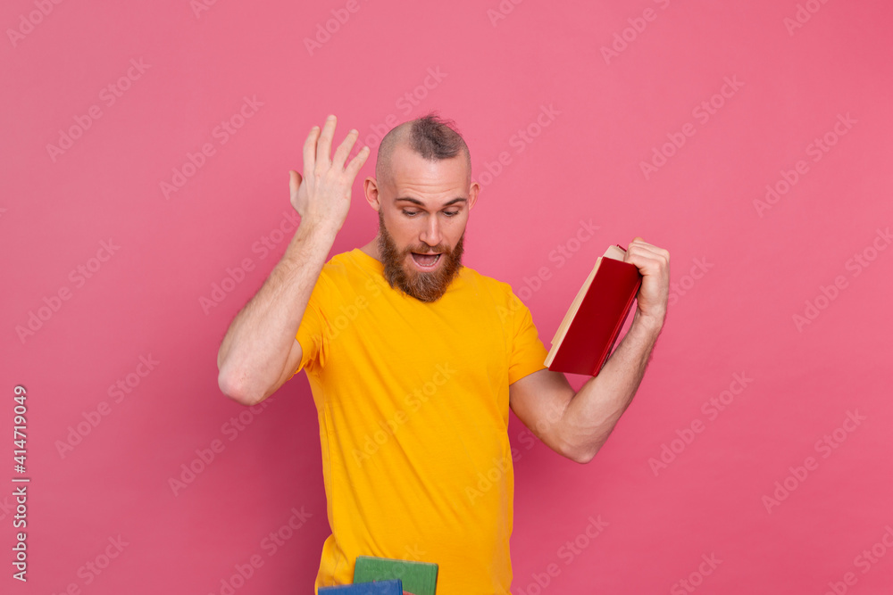 Bearded european man with stack of books on pink background Bearded european man with stack of books on pink background