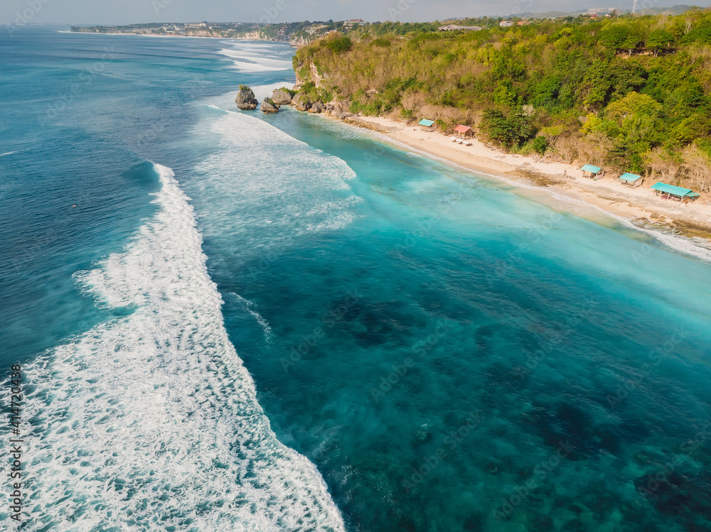 Aerial view of waves in ocean and coastline with Thomas beach in Bali