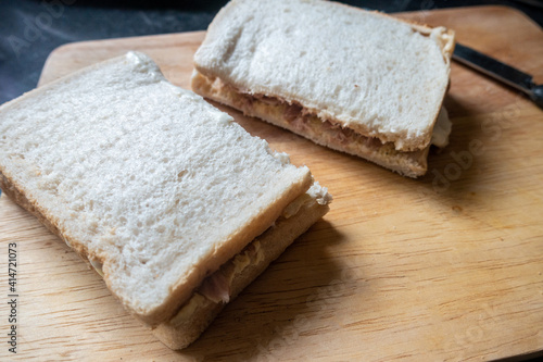 A homemade sandwich on a wooden chopping board.