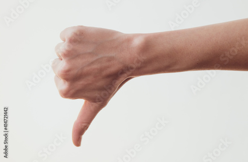 Female hand with thumb down gesture on white background