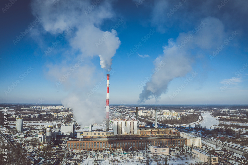 Power plant emitting smoke to the atmosphere against blue sky aerial view
