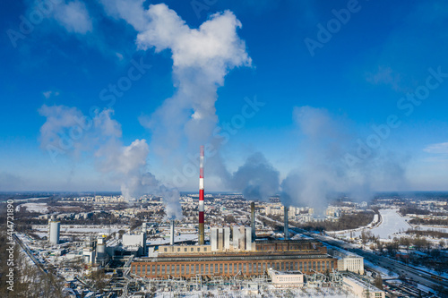 Power plant emitting smoke to the atmosphere against blue sky aerial view