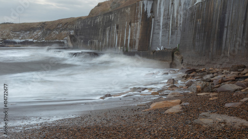 Waves crashing onto the sea wall at Colywell Bay, Seaton Sluice, Northumberland. Engalnd, UK.