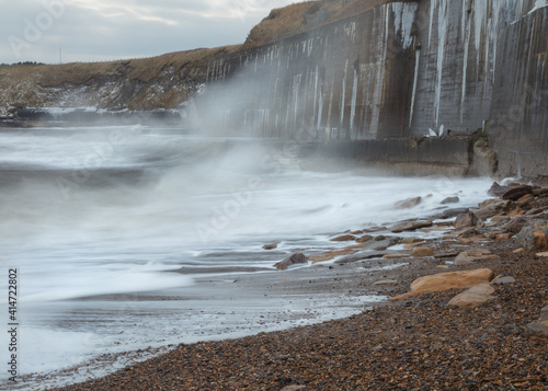 Waves crashing onto the sea wall at Colywell Bay, Seaton Sluice, Northumberland. Engalnd, UK. photo