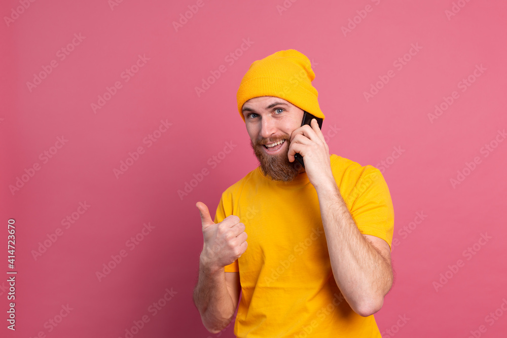 European handsome happy cheerful man talking on smartphone smiling pink background European handsome happy cheerful man talking on smartphone smiling pink background
