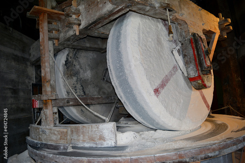 An authentic old millstone at work in the mill