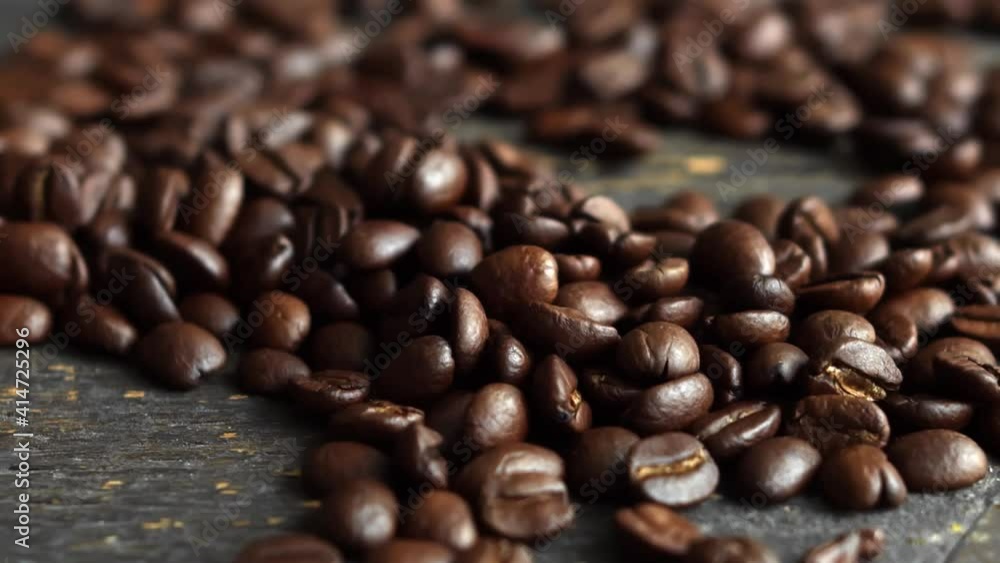 Roasted arabica coffee beans scattered on a wooden table. Fresh coffee beans. Espresso, americano, doppio, cappuccino, latte. Robusta. Selective focus. Roasted arabica coffee beans scattered on a wooden table. Fresh coffee beans. Espresso, americano, doppio, cappuccino, latte. Robusta. Selective focus.