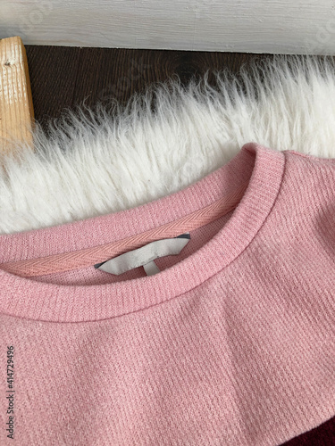 White blank label on the collar of a pink sweatshirt close up