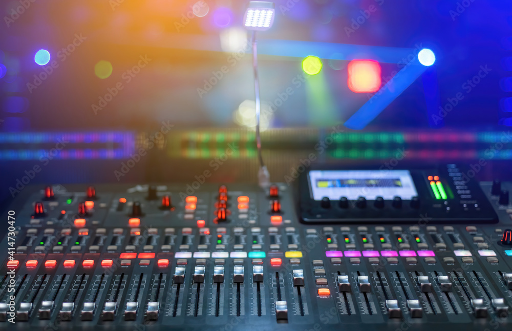 A sound mixing plan for mixing music with lots of buttons and a lighted screen and a nightclub stage background