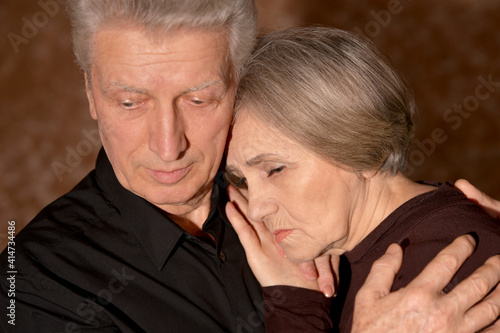 Portrait of sad senior couple posing at home