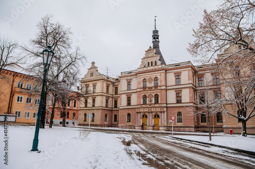 Integrated high school of hotel operations, trade and services, Narrow picturesque street with historical buildings, snow in winter day, Pribram, Bohemia, Czech Republic