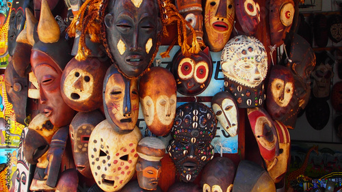 Selection of African masks carved from wood and decorated, some with seashells and others by being engraved