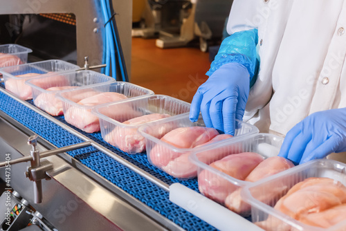 Factory for the production of food from meat.Production line with packaging .Conveyor Belt Food.Food products meat chicken in plastic packaging on the conveyor.