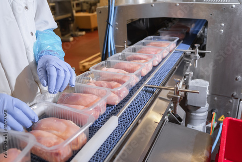 Factory for the production of food from meat.Production line with packaging .Conveyor Belt Food.Food products meat chicken in plastic packaging on the conveyor.