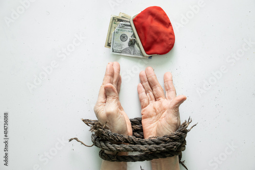 red wallet with american dollars from a woman's hands tied on a white
