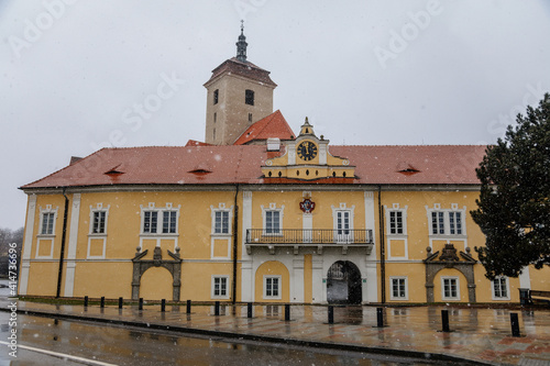 Yellow chateau, Baroque medieval castle with stone gothic tower, historical building on the Otava, snow in winter day, Strakonice, Southern Bohemian region, Czech Republic