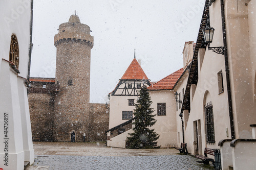 Renaissance courtyard, Baroque medieval castle with stone gothic tower, historical building on the Otava, snow in winter day, Strakonice, Southern Bohemian region, Czech Republic photo