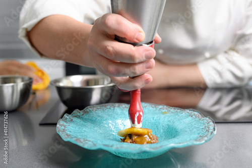Professional chef holding a foam siphon in a restaurant kitchen. High quality photo photo