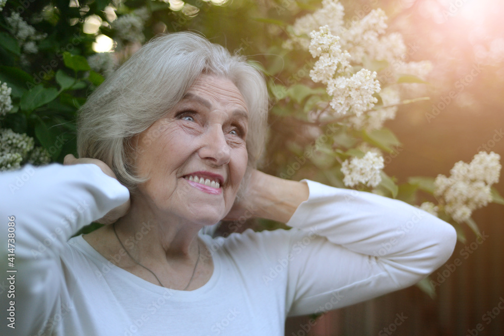senior beautiful woman posing with lilacs in park senior beautiful woman posing with lilacs in park