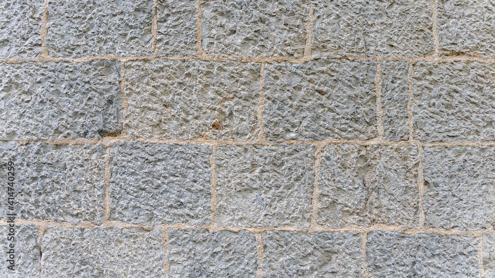 old stone wall made of sandstone blocks of different sizes as background