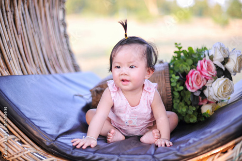 Portrait asia baby girl of 8 months old enjoying, Cute infant child toddler sitting in pink dress