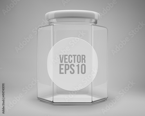 Hexagon glass honey jar with a lid. A transparent jar with a white lid and label.
