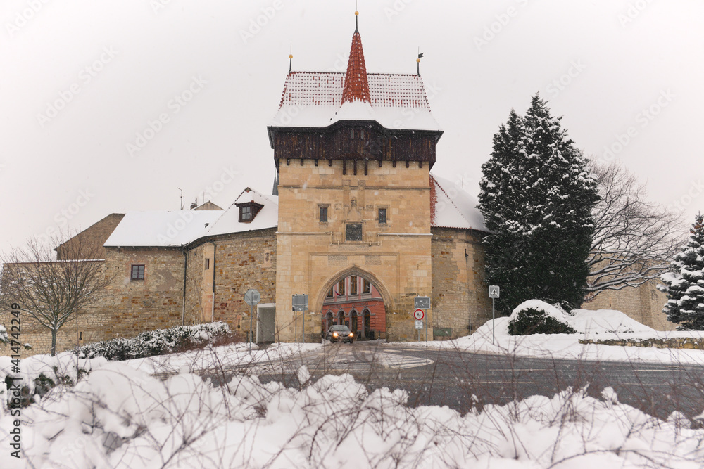 Old town gate, Zatec Gate in Louny town, Czech Republic. Louny city in Czechia north region in winter.  Medieval fortification stone walls and gate. 