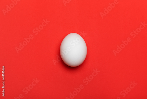 Canvas Print White egg on bright red background