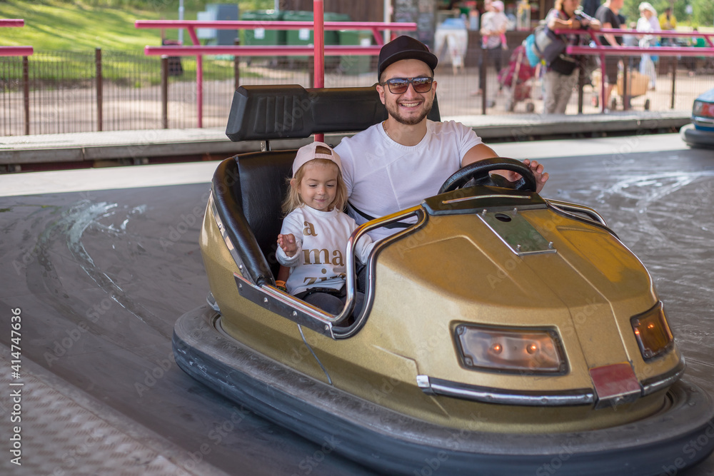 Father and daughter in bumper car at fun fair. Father and daughter in bumper car at fun fair.
