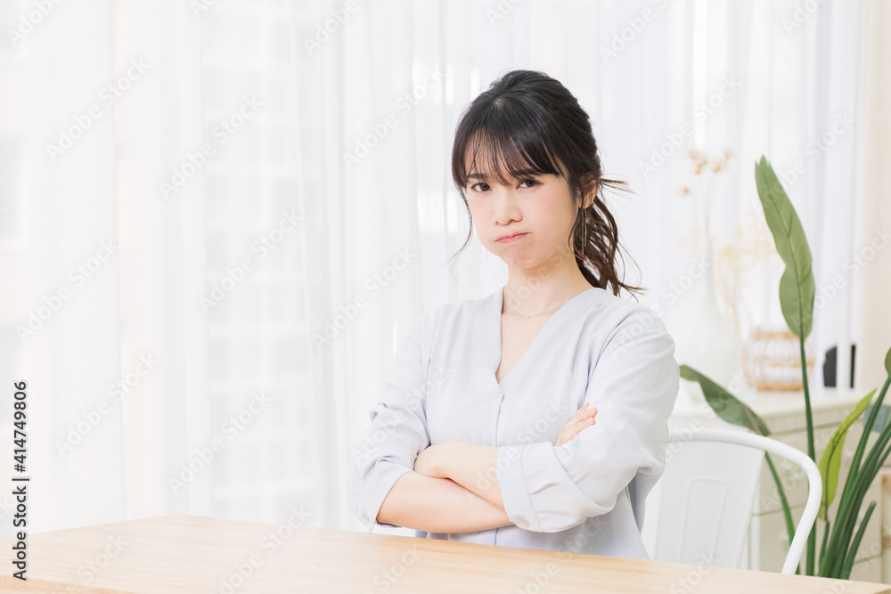 部屋で怒っているジェスチャーをする若い女性