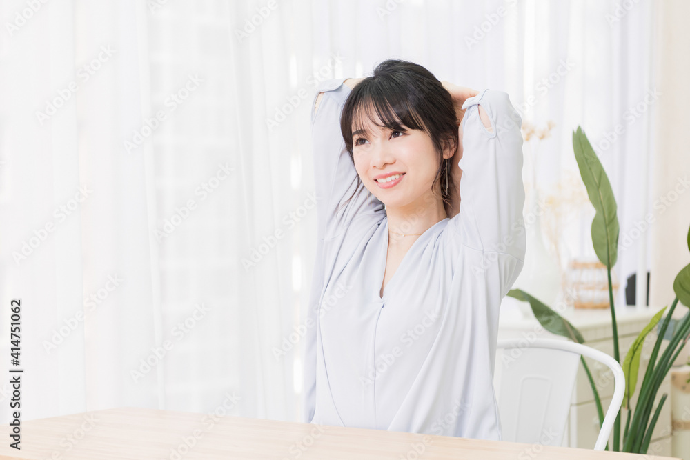 部屋でストレッチをする若い女性 部屋でストレッチをする若い女性