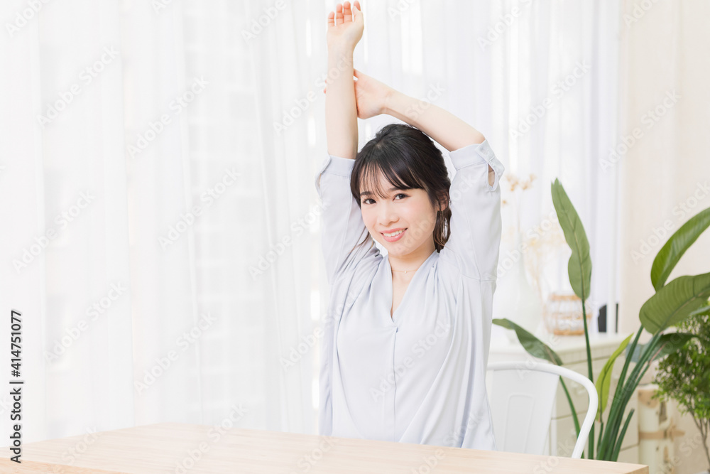 部屋でストレッチをする若い女性