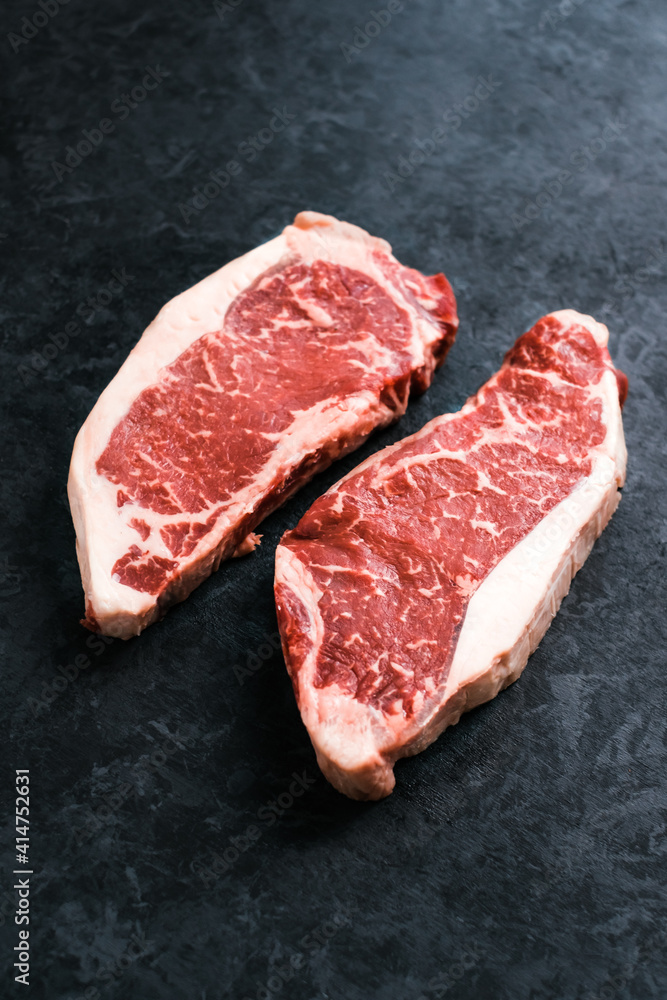 Raw New York striploin beef steak isolated on black background