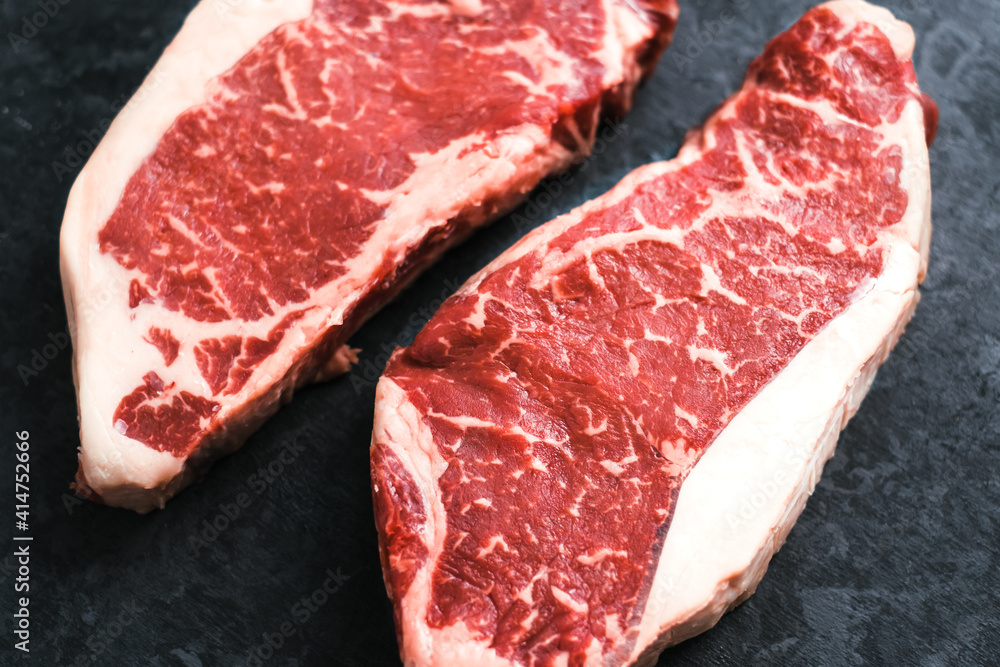 Raw New York striploin beef steak isolated on black background