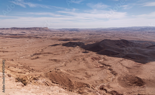 view of Mount Ardon and Givat Gaash in the Makhtesh Ramon crater in Israel from the Gaash Overlook with a beautiful partly cloudy sky in the background