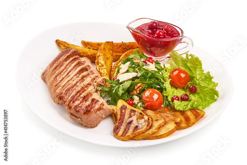 Grilled beef steak with potato wedges, grilled pears and arugula salad with feta cheese, isolated on white background