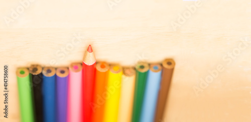 Stay sharp and stand out concept, Sharp tip pencil stand out from the others blur pencils on wood background photo