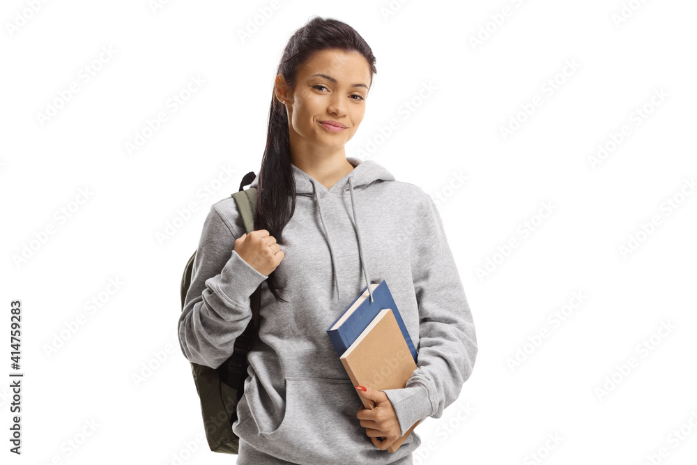 Schoolgirl with backpack and books smiling at the camera